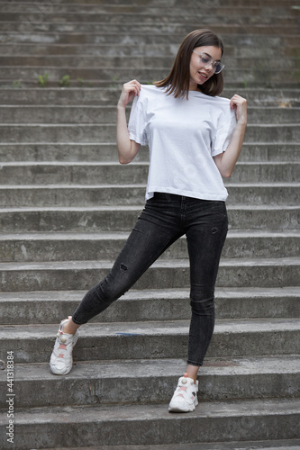 Girl or woman wearing white blank t-shirt with space for your logo, mock up or design in casual urban style © 4Max