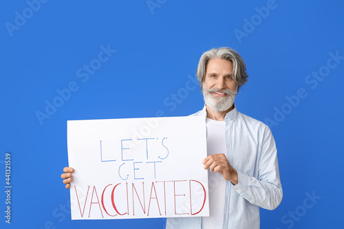 Senior man holding poster w...