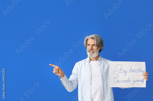 Senior man holding poster w...