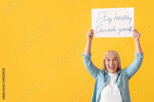Senior woman holding poster...
