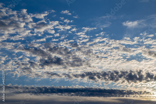 Beautiful blue sky with white cirrus clouds at sunset. Sky panorama for screensavers, postcards, calendar, presentations. Low point at wide angle. Warm spring or summer evening.