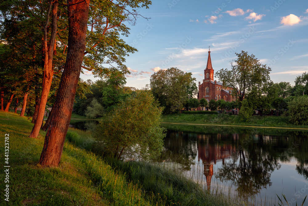 View of the Lutheran Church of the Resurrection of Christ in Tsarskoye Selo on the bank of the 4th Lower Pond in the first rays of the dawn sun, Pushkin, St. Petersburg, Russia