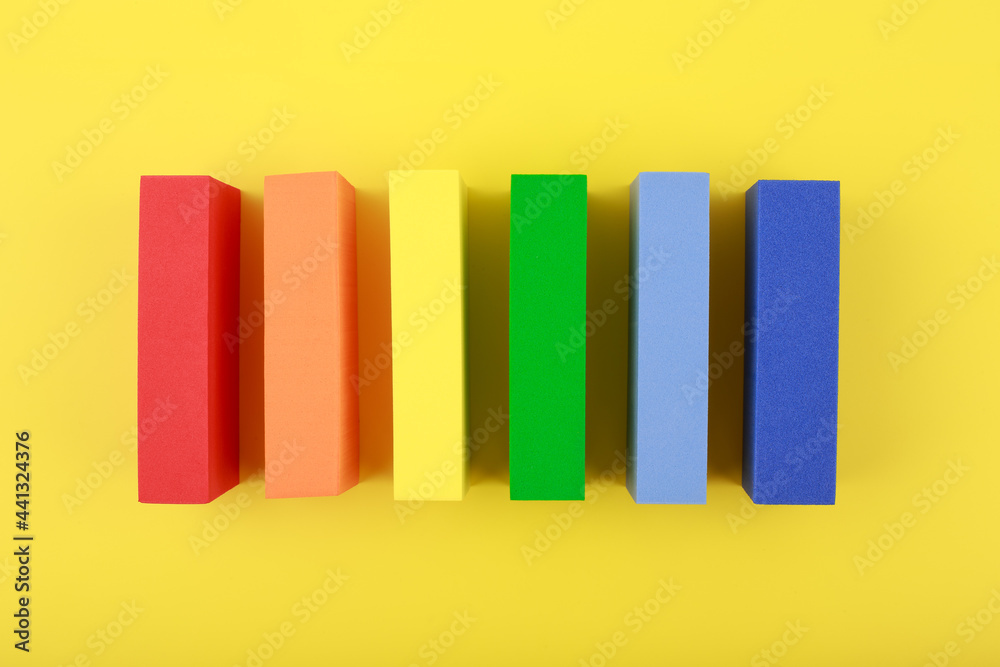 Creative flat lay with lgbt rainbow flag made of rectangular geometric figures on yellow background. Concept of Pride Month, Lgbtq plus community, respect and tolerance. Creative flat lay with lgbt rainbow flag made of rectangular geometric figures on yellow background. Concept of Pride Month, Lgbtq plus community, respect and tolerance.