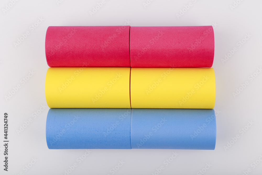 Flat lay with pansexual flag made of pink, yellow and blue rolls on white background. Concept of pansexual community, sexual minorities, equal right and tolerance