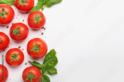 Fresh ripe tomatoes, spices and basil leaves on white background