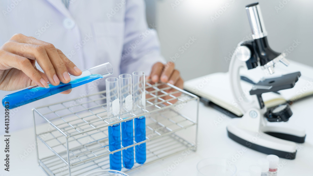 Scientist wear lab coat and protective wear are working with research or doing investigations with test tubes in experiment, Laboratory and development concept Scientist wear lab coat and protective wear are working with research or doing investigations with test tubes in experiment, Laboratory and development concept