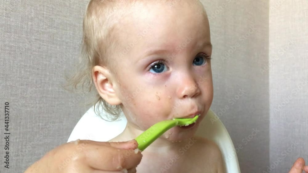 a little girl with pleasure and interest tries and eats porridge on her own. High quality 4k footage a little girl with pleasure and interest tries and eats porridge on her own. High quality 4k footage