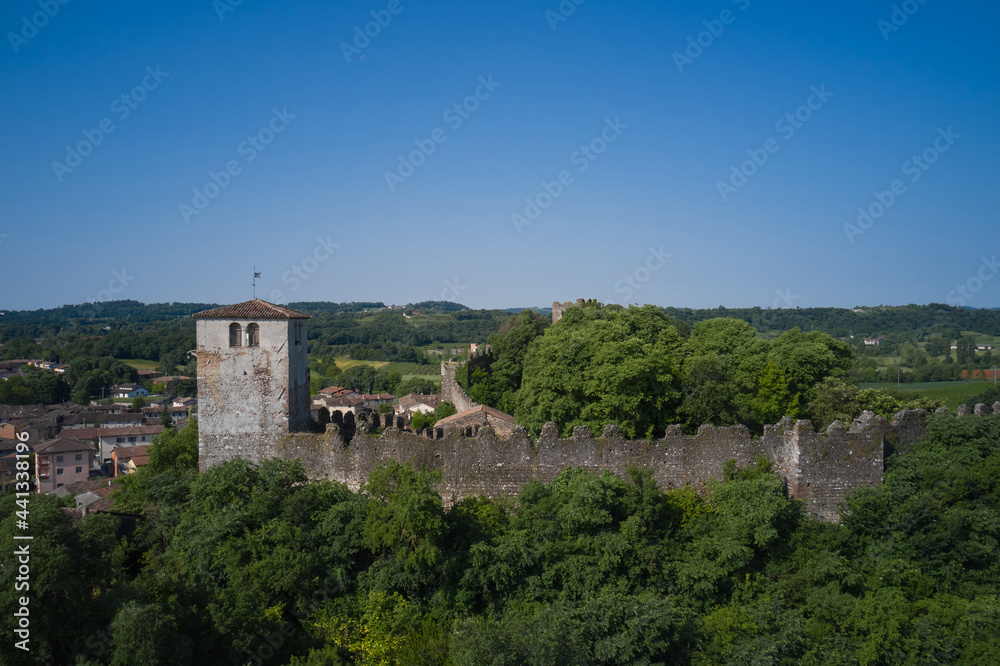 Monzambano Castle, Italy. Aerial view of the Italian historic castle Castello di Monzambano on the hill. Old clock on the tower of the castle.