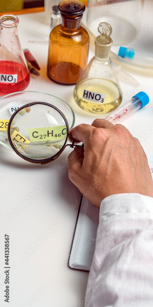Fototapeta premium Food specialist looking at a plate with the name of a food additive through a magnifying glass, food quality. Vertical format.
