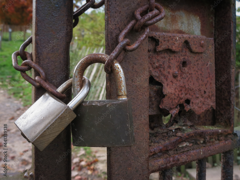 chain and padlocks on a rusty metal gate chain and padlocks on a rusty metal gate
