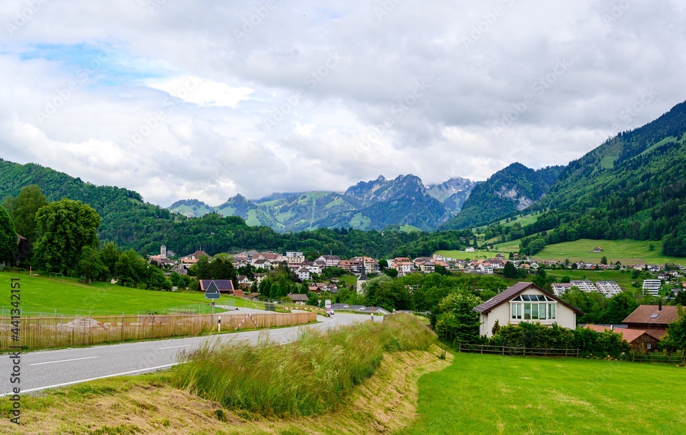 Obraz premium View on alps mountain, green fields Bulle, kanton Fribourg, Freiburg nearby Bern. Castle Greyerz Good hiking tourist way. Switzerland.