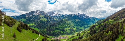 View on alps mountains, green fields, cloudy sky by Jaun,  Jaunpass. Canton Fribourg, Freiburg nearby Bulle, Bern, Thun. Good hiking tourist way. Switzerland. photo