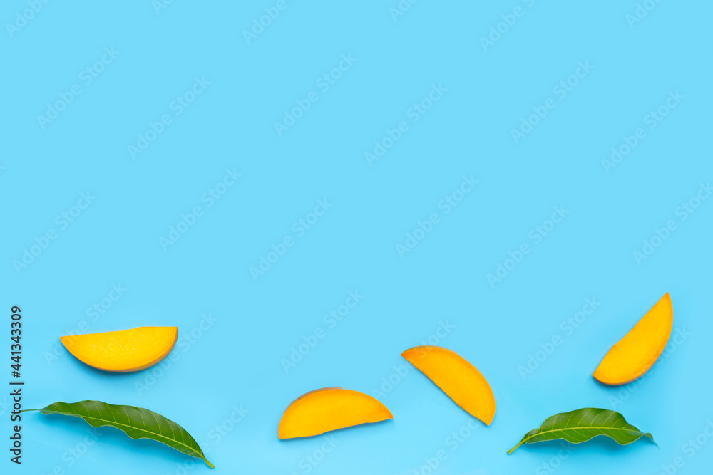 Tropical fruit, Mango slices with leaves on blue background. Tropical fruit, Mango slices with leaves on blue background.