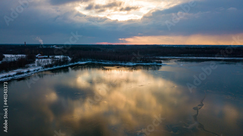 Aerial view of a beautiful and dramatic sunset over a forest lake reflected in the water  landscape drone shot. Blakheide  Beerse  Belgium. High quality photo