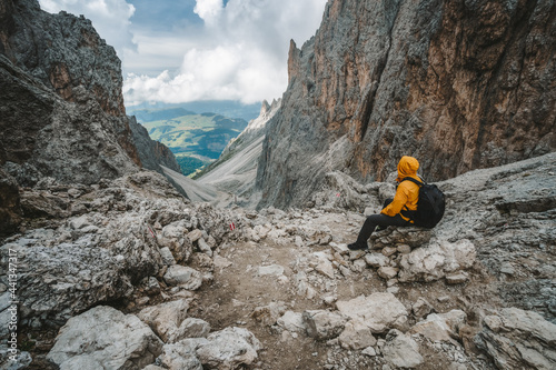 Man hiker taking rest at Pass on Mountain Sassolungo - Langkofel, Alpe di Siusi, Dolomiti mountain - South Tyrol, Italy, Europe, UNESCO World Heritage Site photo