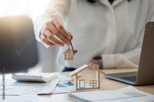 Fotografía Female hand holding house key,real estate agent woman working house loan at her