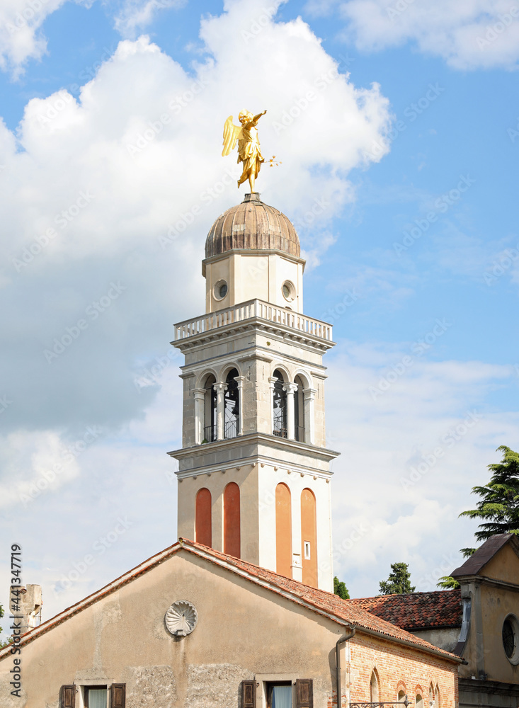 golden statue of an angel above the bell tower in the hill overlooking the city of Udine in Italy