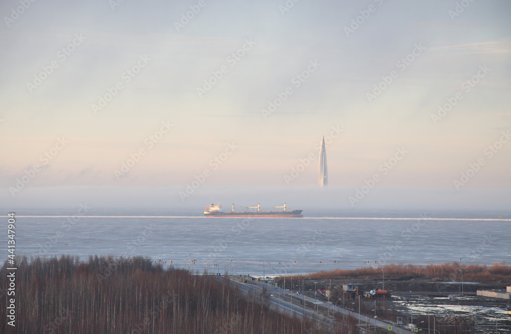 Large cargo ship in the Gulf of Finland. Winter. skyscraper lakhta center in background. Fog, beautiful landscape. Baltic pearl, St. Petersburg. High quality photo