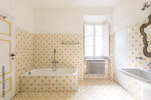 Interior of an old bathroom with window and bathtub. Nobody in this very romantic room.