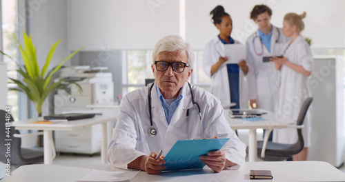 Wallpaper Mural Portrait of senior caucasian male doctor in office consulting patient on video call. Torontodigital.ca