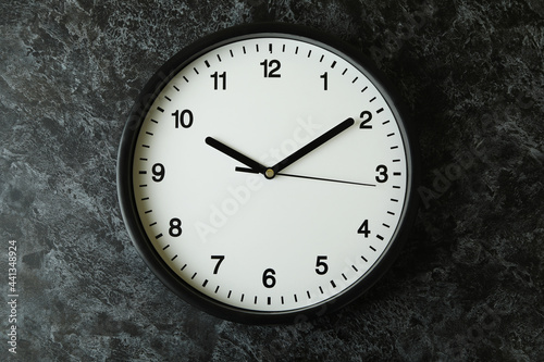 Standard black office clock on black smokey background