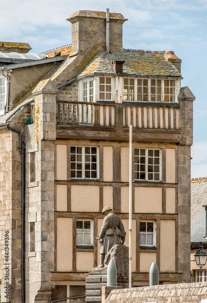 Monument aux Morts et maison traditionnelle normande à Barfleur, Manche, France