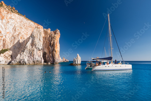 Boats at anchor in the turquoise sea of the south coast of the uninhabited island of Poliegos near Milos in the Greek Cyclades