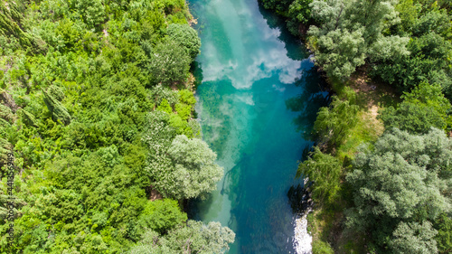 Aerial drone view of river in nature. Beautiful green river and forest in spring. 