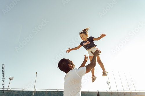 Portrait of a father and daughter playing and having fun - freedom concept 