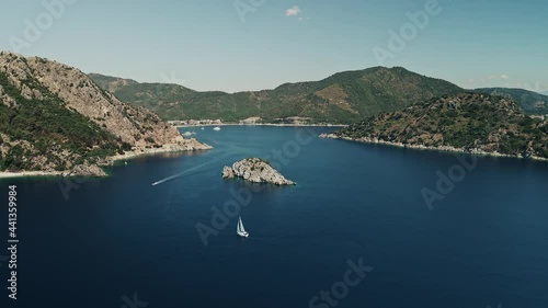 Aerial view of the sea with mountains and a sailboat in the Aegean Sea, the Bay, in the background Turkey Icmeler