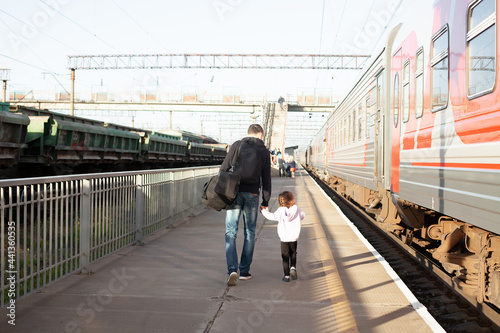 Dad and daughter on the railway platform. Travelling by train. Rest with your child. Holidays during a pandemic. Family tourism. summer. By the hand. 