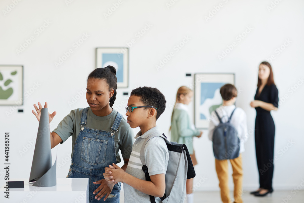 © Seventyfour - Minimal portrait of schoolchildren visiting art gallery and looking at modern sculptures, copy space