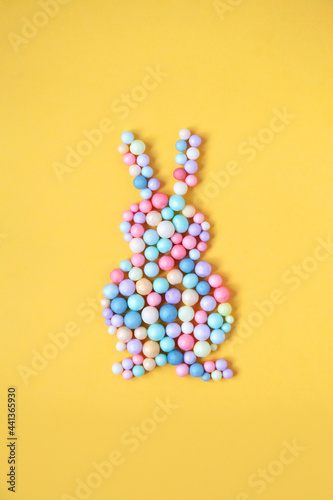 Pastel easter rabbit silhouette isolated on yellow background. Easter concept, minimalist flat lay layout, top view.