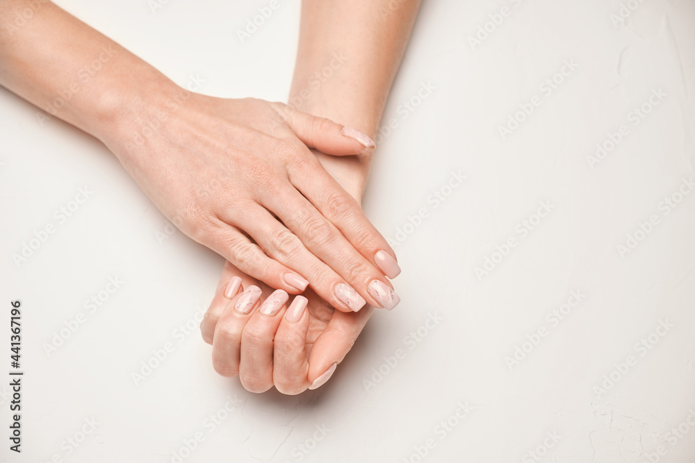 Obraz premium Woman hands with beautiful manicure on light background