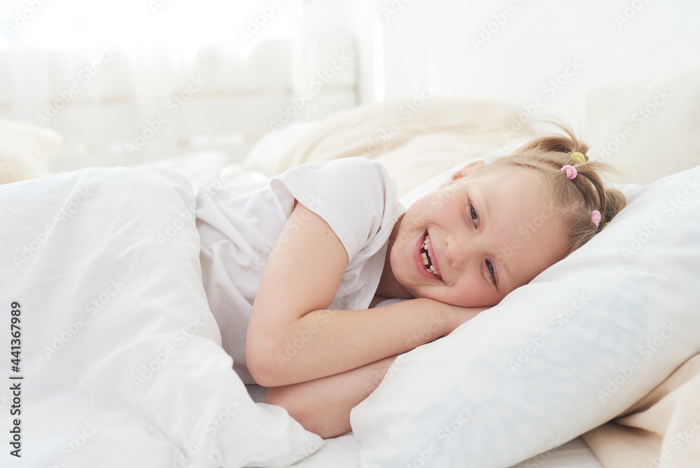 A little girl wakes up in the morning and smiles. Good dream A little girl wakes up in the morning and smiles. Good dream