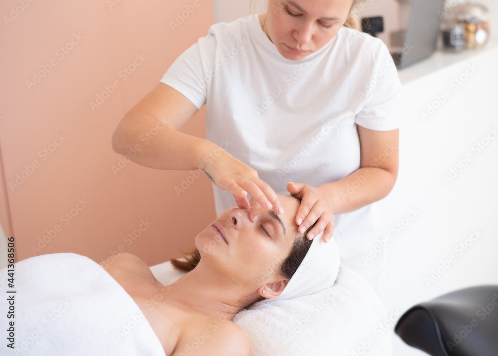 Cleaning and moisturise nourish skin of face. Cosmetologist make massage of face. Beautiful woman receives facial peeling. Treatment skin care in cosmetology beauty spa salon.