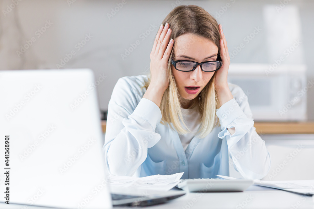 young female housewife sitting a table in house kitchen an incomprehensible deal with paperwork bills and loans. Woman is exhausted and frustrated with documents of enterprise or family budget at home young female housewife sitting a table in house kitchen an incomprehensible deal with paperwork bills and loans. Woman is exhausted and frustrated with documents of enterprise or family budget at home
