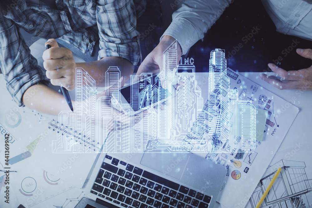 Double exposure of town hologram and man and woman working together holding and using a mobile device. Smart city concept. Double exposure of town hologram and man and woman working together holding and using a mobile device. Smart city concept.