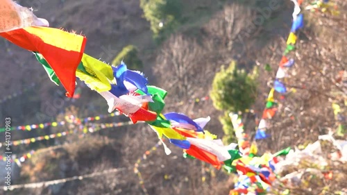 Close-up slow motion shot of the Colorful Buddhist Bhutanese Tibetan prayer flag covering the mountains at Pangan Nyingma Monastery in Patlikuhal village near Manali, Himachal Pradesh, India	 photo