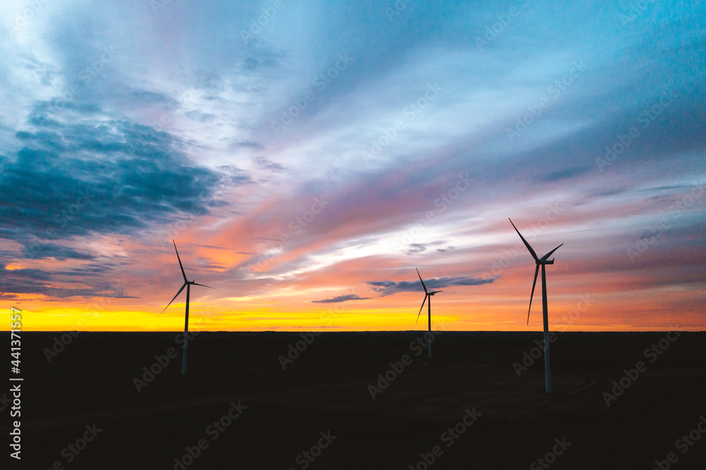 Aerial view of wind farm turbines in a sunset sky in Lithuania. Aerial view of wind farm turbines in a sunset sky in Lithuania.