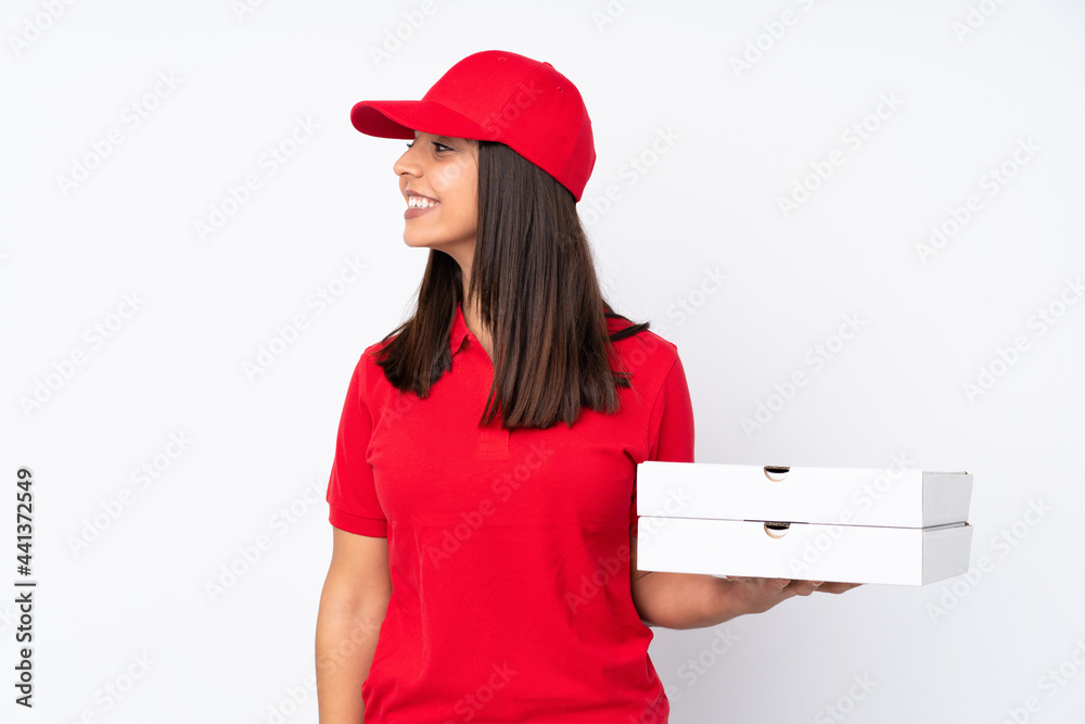 Young Pizza delivery girl over isolated white background looking side Young Pizza delivery girl over isolated white background looking side
