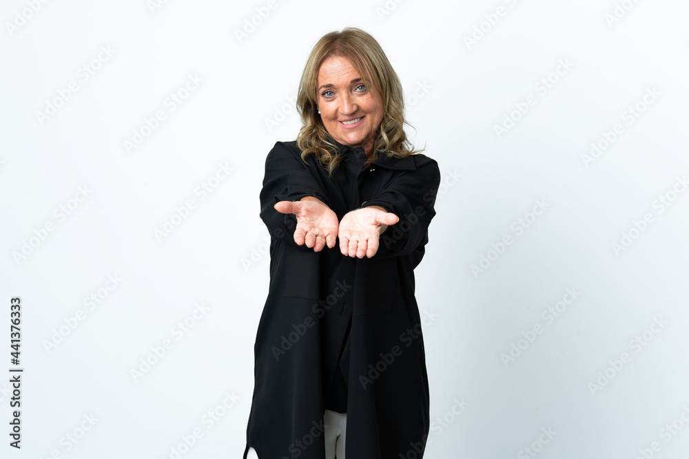 Middle aged blonde woman over isolated white background holding copyspace imaginary on the palm to insert an ad Middle aged blonde woman over isolated white background holding copyspace imaginary on the palm to insert an ad