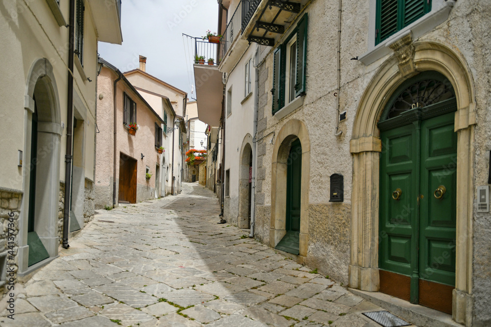 Obraz premium A small street between the old houses of Agnone, a medieval village in the mountains of the Molise region, Italy.