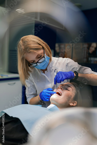 The dentist treats the patient's teeth. Puts braces on a girl. Dentist's office.