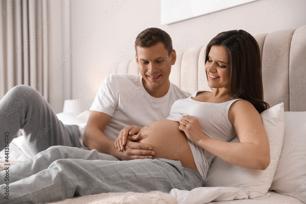 Young pregnant woman with her husband in bedroom Young pregnant woman with her husband in bedroom