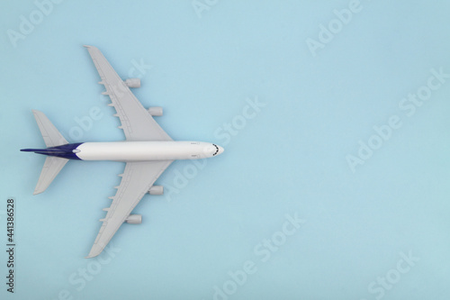 Airplane model on blue background., top view. Travel and transportation concept. Space for text. 
