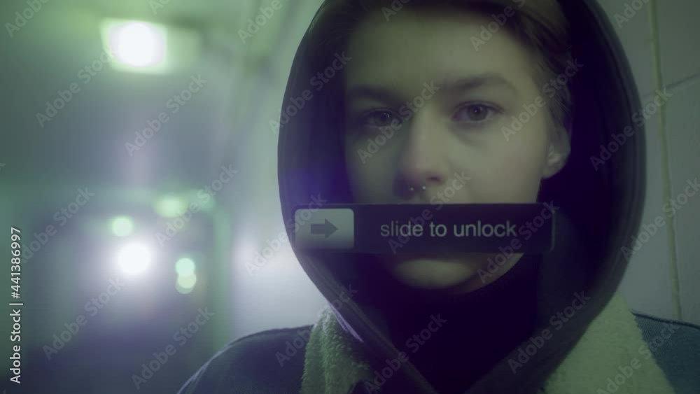 Caucasian girl with a short haircut in a hood and denim jacket stands in a pedestrian crossing, holds a sign with the inscription - Slide to unlock Caucasian girl with a short haircut in a hood and denim jacket stands in a pedestrian crossing, holds a sign with the inscription - Slide to unlock