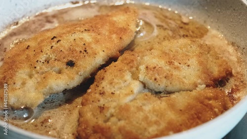 Preparation of marinated chicken breast in breadcrumbs in a frying pan in olive oil. Cook's preparation of chicken and chicken fillet.