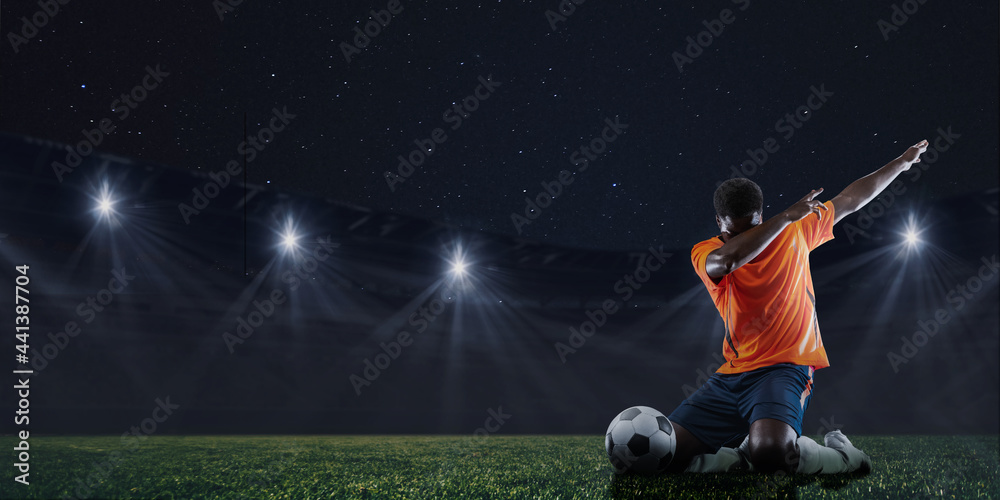 Win, victory. Male soccer, football player after football match isolated on sky background at stadium with flashlights