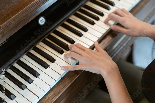 banner close up picture of hand of young woman playing piano at home